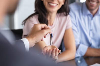 Man handing house key to couple